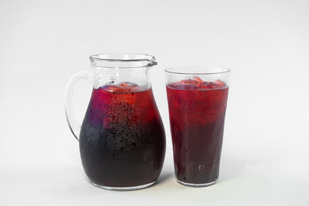 A pitcher and a glass filled with liquid